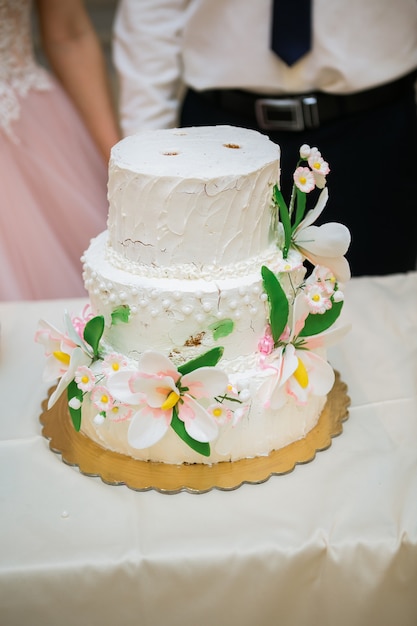 torta nuziale bianca a più livelli con decorazioni floreali