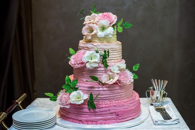 Torta nuziale decorata con fiori rosa e bianchi