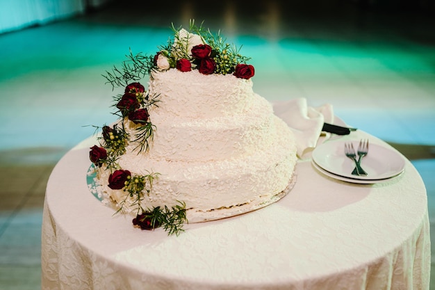 Torta nuziale Una classica torta bianca a più livelli decorata con fiori sul tavolo