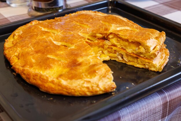 Torta osseta domestica appena sfornata su una teglia con pezzo tagliato sopra vista ravvicinata