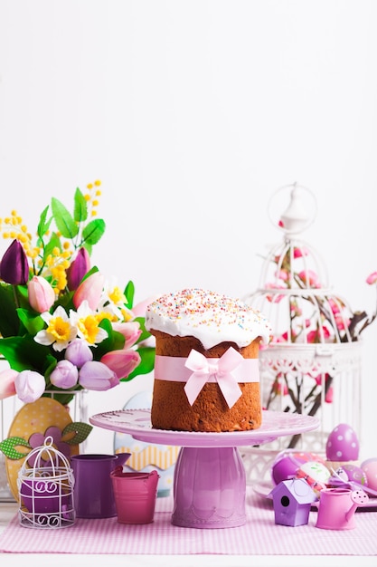 Torta pasquale sull'alzata e fiori, desorazioni lilla in primo piano con spazio per le copie