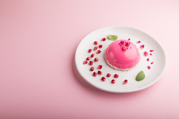 Torta rosa della mousse con la fragola su una priorità bassa di colore rosa pastello. vista laterale, copia spazio.