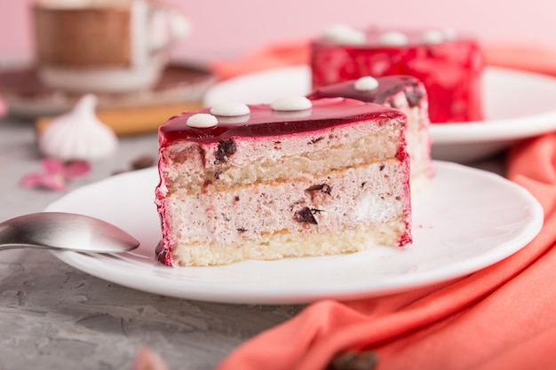 Torta rossa affettata con crema di soufflé con la tazza di caffè su una superficie di calcestruzzo grigia. vista laterale, messa a fuoco selettiva.