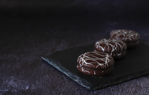 Torta rotonda al cioccolato in glassa bianca su sfondo scuro