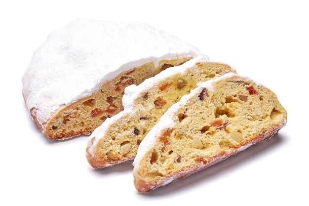 Torta stollen tradizionale a fette di Natale con marzapane e frutta secca isolata su sfondo bianco