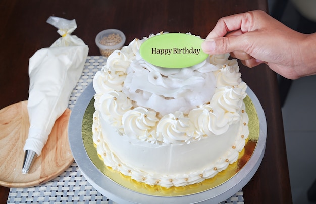 Torta sul basamento con la parola dell&#39;etichetta della tenuta della mano