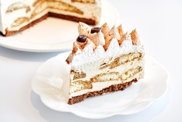 Torta tiramisù al caffè su un piatto bianco. Deliziosa bella vista laterale del dessert festivo