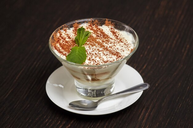 Torta tiramisù dolce in vetro con foglie di menta