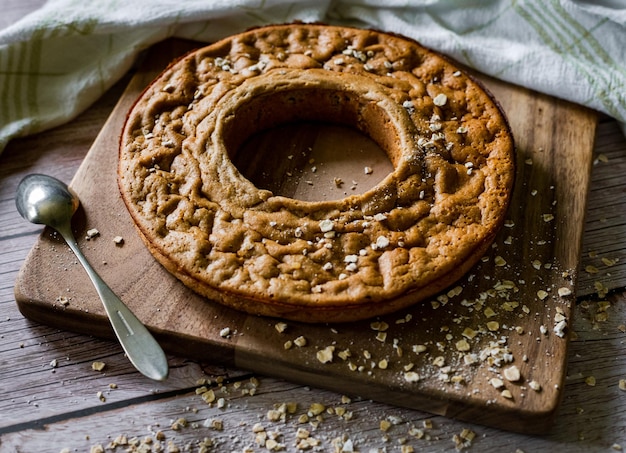 Torta tonda con un buco al centro con fiocchi d'avena sparsi