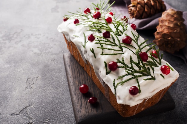 Torta tradizionale di natale con i mirtilli rossi sulla tabella grigia. Orizzontale. Copia spazio.