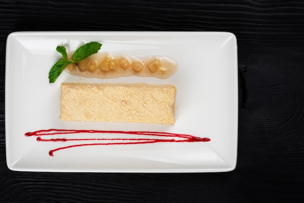 Torta tradizionale Esterhazy con menta su fondo di legno nero