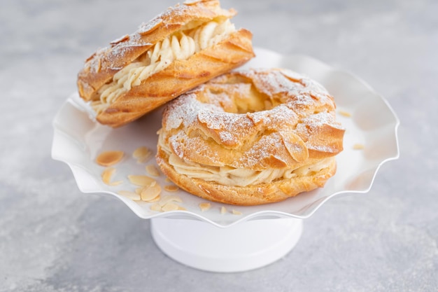 Torta tradizionale francese Paris Brest con crema pralinata di zucchero a velo e petali di mandorle Spazio di copia