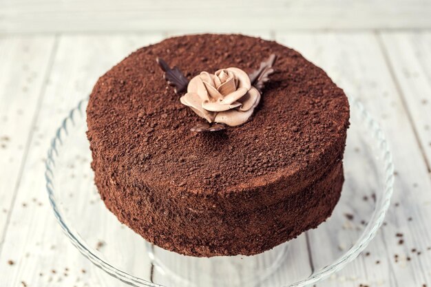 Torta vegana al cioccolato fondente con caramelle e crema su fondo di legno