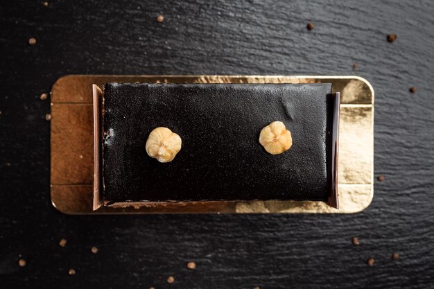 Torta vegana al cioccolato fondente con caramelle e noci su fondo di legno