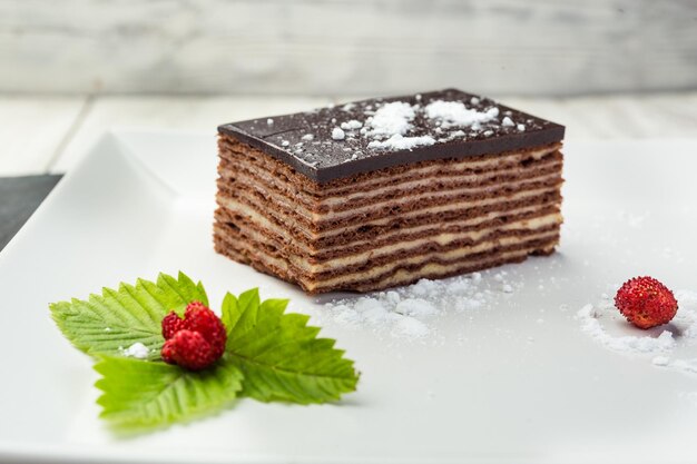 Torta vegana al cioccolato fondente con caramelle e noci su fondo di legno