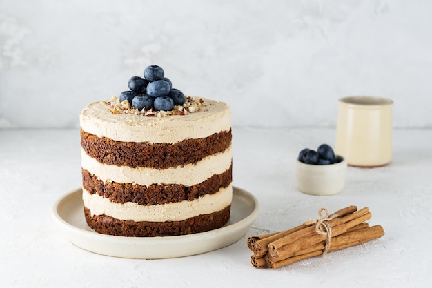 Torta vegana di carote con crema di cocco mirtilli noci e spezie in tavola