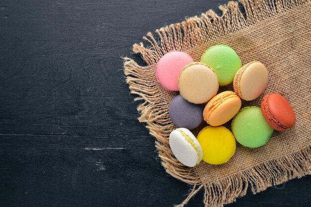 Torte colorate di macarons su uno sfondo di legno Vista dall'alto Spazio libero per il testo