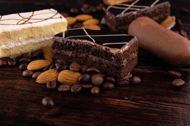 Torte con cioccolato e glassa bianca, mandorle e chicchi di caffè in primo piano.