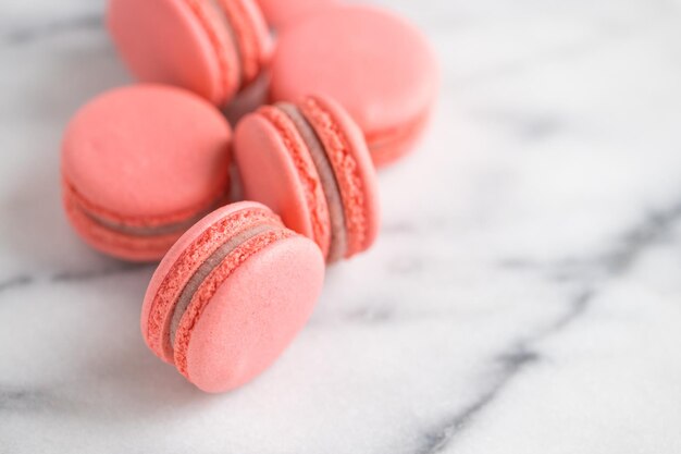 Torte di corallo macarons o amaretti su marmo bianco