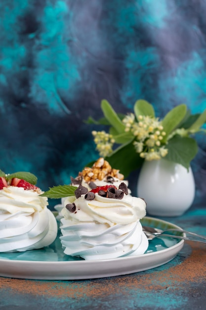 Torte di meringa Pavlova con panna montata e fragole fresche foglie di menta Messa a fuoco selettiva