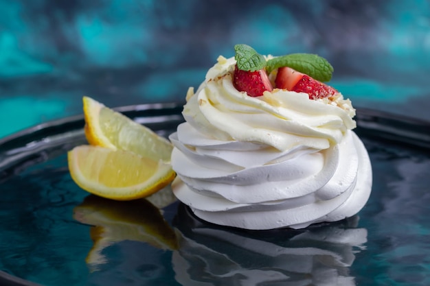 Torte di meringa Pavlova con panna montata e fragole fresche foglie di menta Messa a fuoco selettiva