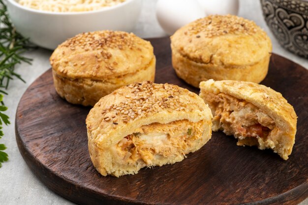 Torte di pollo fatte in casa su tavola di legno con ingredienti.