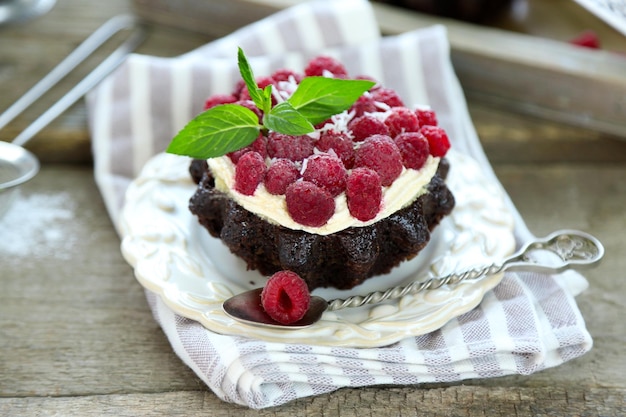 Torte dolci con lamponi su sfondo tavolo in legno