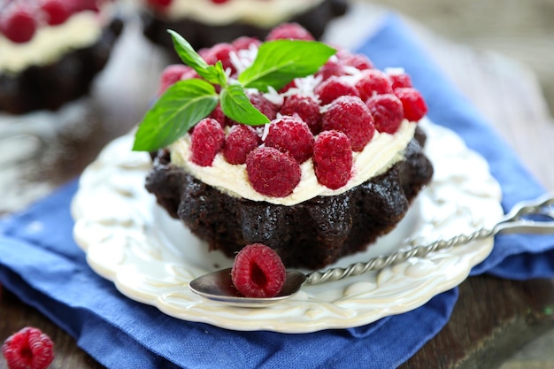 Torte dolci con lamponi su sfondo tavolo in legno