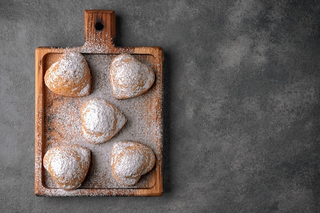 Torte fatte in casa, muffin con zucchero a velo, su una tavola di legno, su un tavolo grigio