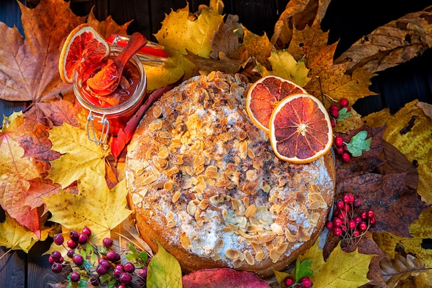 Torte fatte in casa, noci, arance, marmellate decorate con foglie d'autunno. Scena autunnale,