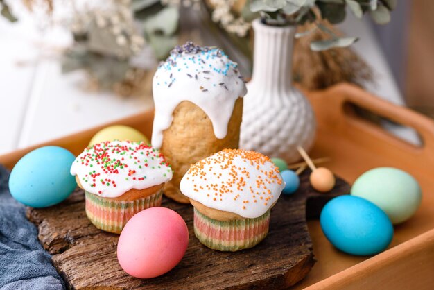 Torte festive con glassa bianca, noci e uvetta con uova di Pasqua sulla tavola festiva