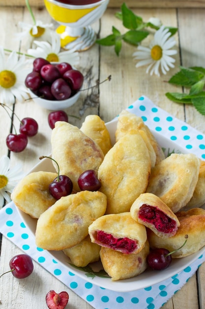 Torte fritte Torte dolci con ciliegie sul tavolo della cucina in stile rustico