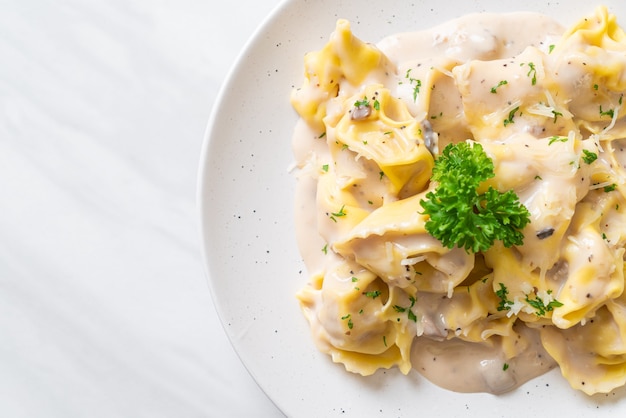 tortellini con salsa di crema di funghi e formaggio - stile alimentare italiano