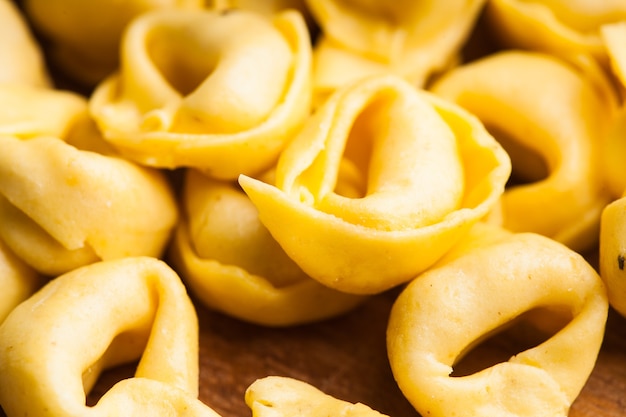 Tortellini crudi sulla tavola di legno, preparati per la cottura