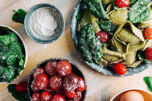 Tortellini di spinaci Ingredienti per preparare tortellini di spinaci fatti in casa su assi di legno. Copia spazio