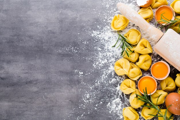 Tortellini italiani crudi fatti in casa e foglie di basilico