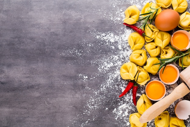 Tortellini italiani crudi fatti in casa e foglie di basilico.