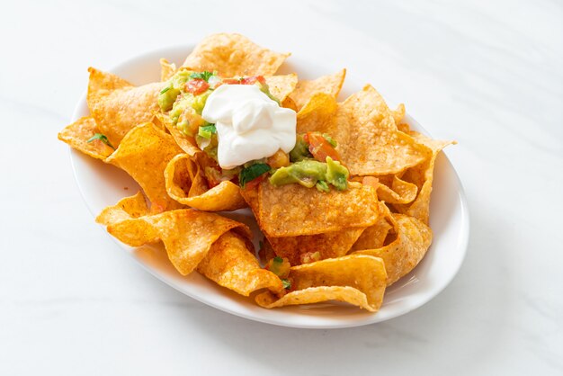 Tortilla chips di nachos messicani con jalapeno, guacamole, salsa di pomodori e dip