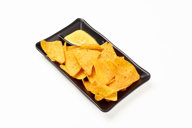 Tortilla chips servite con salsa di senape in un piatto isolato su sfondo bianco con tracciato di ritaglio