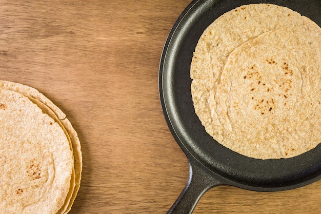 Tortilla multicereali fresche su uno sfondo di legno.