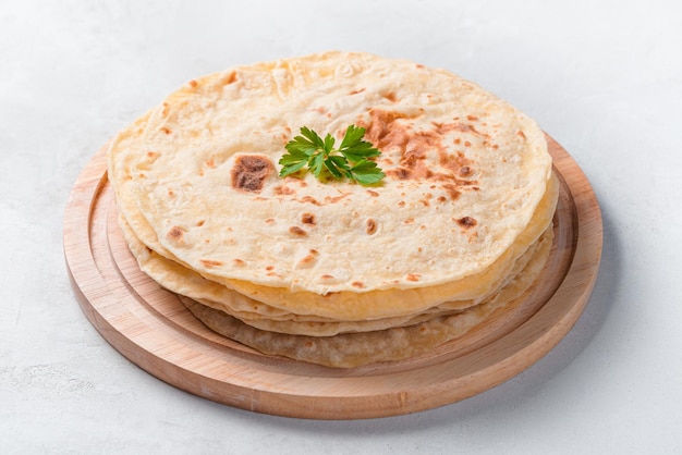 Tortillas chapati tradizionali indiani con erbe fresche closeup su sfondo grigio