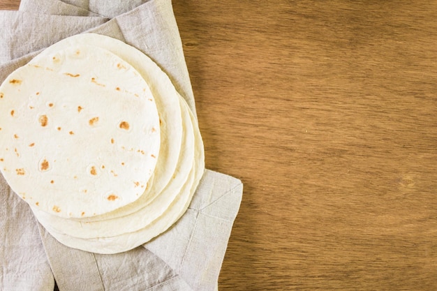 Tortillas di farina fresca su uno sfondo di legno.