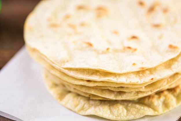 Tortillas di mais bianco fresco su carta bianca.