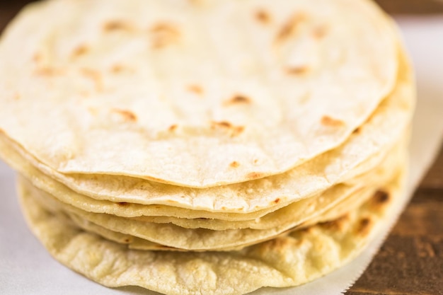 Tortillas di mais bianco fresco su carta bianca.