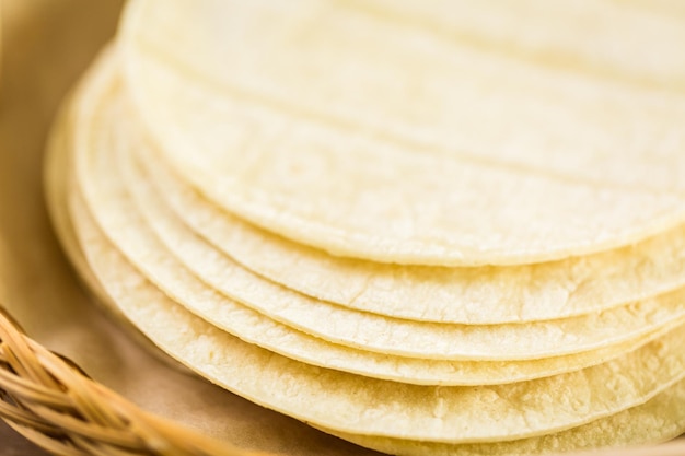 Tortillas di mais bianco fresco su uno sfondo di legno.