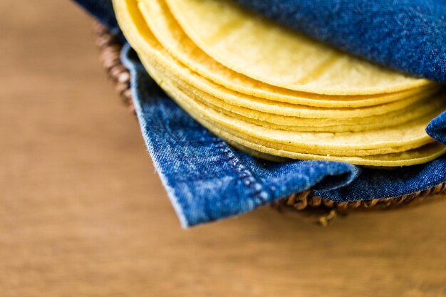 Tortillas di mais giallo fresco su uno sfondo di legno.