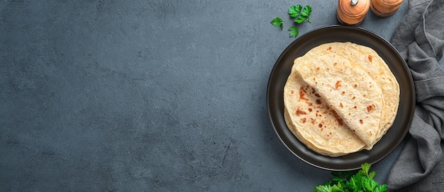 Tortillas tradizionali Chapati con prezzemolo fresco su fondo grafite Focacce indiane