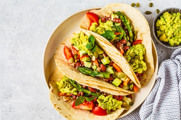 Tortillas vegane con quinoa, asparagi, fagioli, verdure e guacamole.