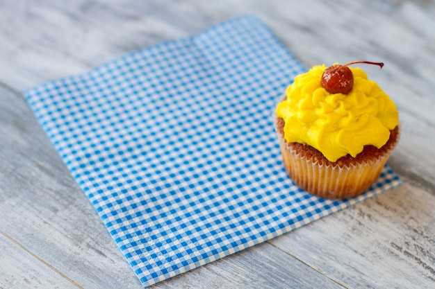 Tortina su tovagliolo a scacchi blu glassa brillante e dessert ai frutti di bosco dal menu della tavola calda solo la migliore pasticceria