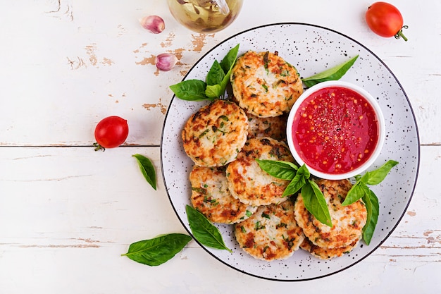 Tortini deliziosi della carne di pollo e del riso con salsa al pomodoro dell'aglio